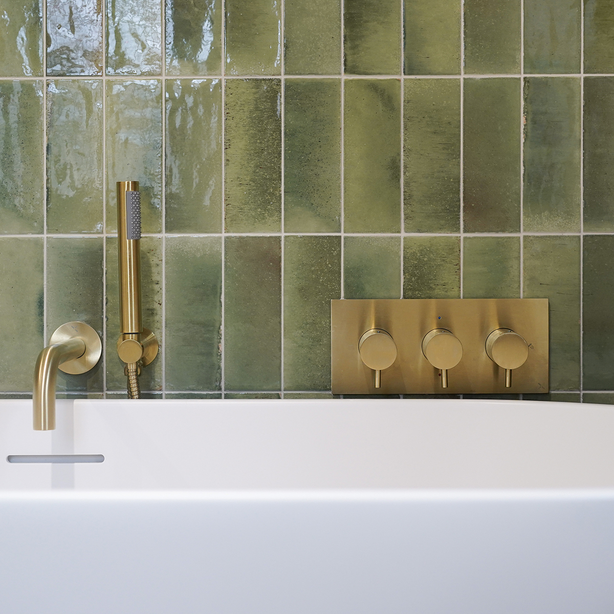Freestanding bath brushed gold accents green tiles