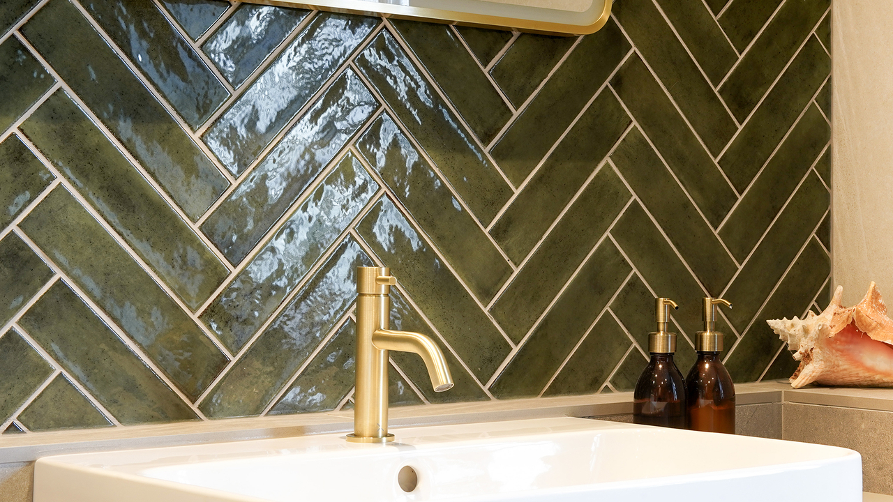Green herrinbone tiles gold taps vanity bathroom